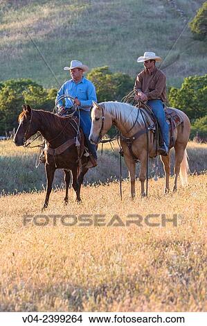 Picture - Two wranglers (cowboys) on horses, California, USA. Fotosearch