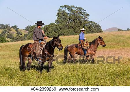 Stock Photo - Two wranglers (cowboys) on horses, California, USA. Fotosearch