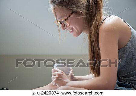 Wellbeing. Girl enjoying a coffee in the morning. View Large Photo Image Picture - Wellbeing. Girl enjoying a coffee in the morning.. Fotosearch