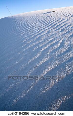 Stock Photograph - Wind has eroded the gypsum sand in these scene to create interesting patterns and textures in White Sands National Monument on a bright sunny day, near Alamogordo, New Mexico, USA.. Fotosearch