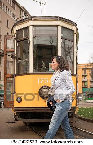 Woman crossing railroad tracks and an old Tram in background in Milan, Italy. View Large Photo Image Stock Photo - Woman crossing railroad tracks and an old Tram in background in Milan, Italy.. Fotosearch