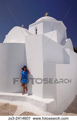 Stock Photo - Woman standing in front of a white church in Plaka, Amorgos, Cyclades Islands, Greek Islands, Greece, Europe.. Fotosearch