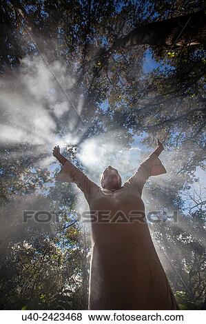 Stock Photo - Woman standing in smoke in forest.. Fotosearch