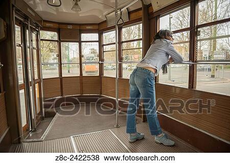 Stock Photo - Woman traveling and looking out on a Tram window in Milan, Italy.. Fotosearch