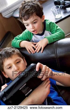 Young boys play a video game. View Large Photo Image Stock Photography - Young boys play a video game.. Fotosearch