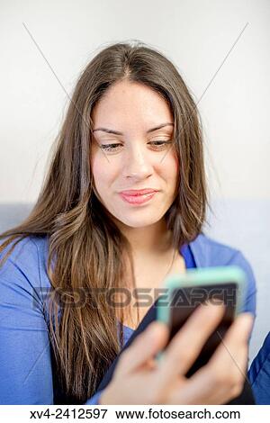 Young Woman chating on her sofa and drinking hot beverage. View Large Photo Image Stock Photo - Young Woman chating on her sofa and drinking hot beverage.. Fotosearch
