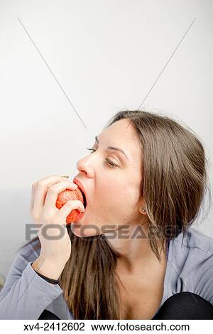Stock Image - Young Woman eating fruit.. Fotosearch