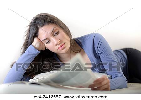 Young Woman reading magazine on her bed. View Large Photo Image Stock Photo - Young Woman reading magazine on her bed.. Fotosearch