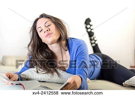 Young Woman reading magazine on her bed. View Large Photo Image Stock Photo - Young Woman reading magazine on her bed.. Fotosearch