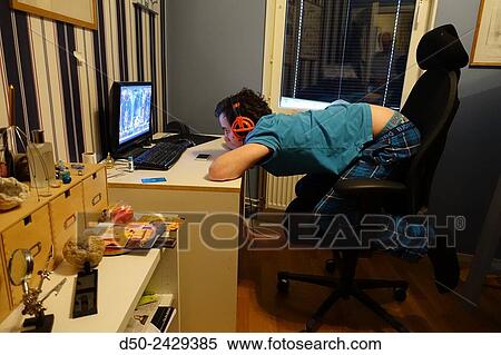 14 year old boy watches TV shows on his computer in his room knweeling on his chair. Stockholm, Sweden View Large Photo Image Stock Photography - 14 year old boy watches TV shows on his computer in his room knweeling on his chair. Stockholm, Sweden. Fotosearch