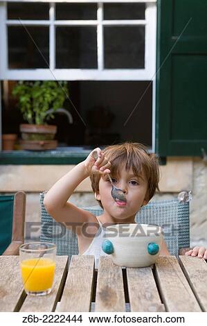 3 years old little girl eating breakfast, Cala San Esteban, Menorca. View Large Photo Image Picture - 3 years old little girl eating breakfast, Cala San Esteban, Menorca.. Fotosearch