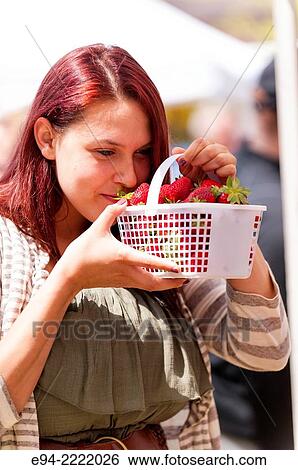 A 24 year old brunette woman smelling fresh strawberries in an outdoor market. View Large Photo Image Stock Photograph - A 24 year old brunette woman smelling fresh strawberries in an outdoor market.. Fotosearch
