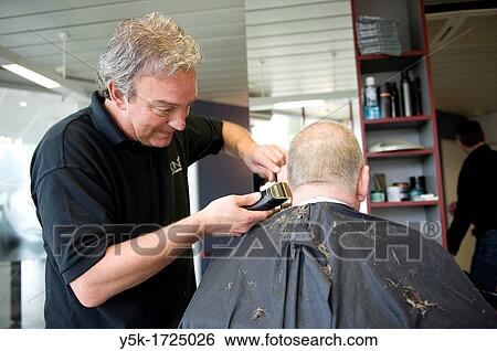 A barber giving a male customer a haircut. View Large Photo Image Stock Photograph - A barber giving a male customer a haircut.. Fotosearch