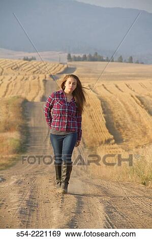 A happy teen girl walking on a rural dirt road. View Large Photo Image Stock Photo - A happy teen girl walking on a rural dirt road.. Fotosearch