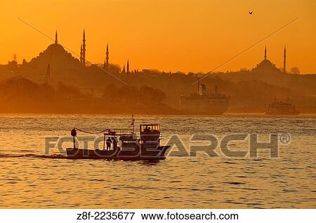 A small fishing boat sails up from the Sea of Marmara into the Bosphorus at sunset, with the skyline of Istanbul´s Old City as a backdrop. View Large Photo Image Stock Photo - A small fishing boat sails up from the Sea of Marmara into the Bosphorus at sunset, with the skyline of Istanbul´s Old City as a backdrop.. Fotosearch