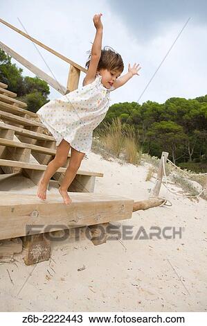 Almost 3 years old little girl jumping from a stair on a beach in Menorca, Spain. View Large Photo Image Stock Image - Almost 3 years old little girl jumping from a stair on a beach in Menorca, Spain.. Fotosearch