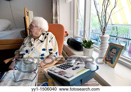 Stock Image - An elderly inhabitant of a Rotterdam nursing home, sitting in the chair of her private living room.. Fotosearch