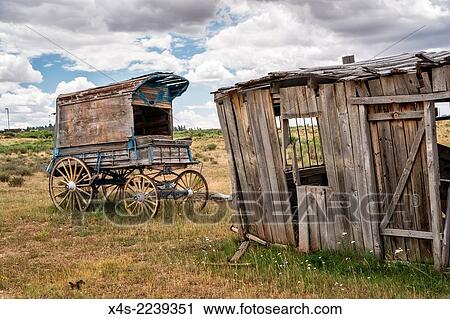 Stock Image - An old west sheriff´s wagon sits on the lonesome frontier prarie as storm clouds gather in the distance.. Fotosearch