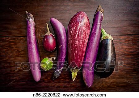 Stock Image - arranged eggplants on table top.. Fotosearch