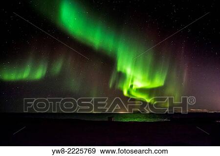 Stock Photo - Aurora Borealis or Northern Lights by the town of Gardur, Reykjanes Peninsula, Iceland.. Fotosearch
