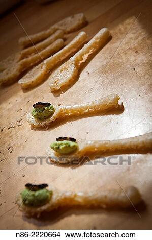 Picture - baked parmesan cheese spoons preparation.. Fotosearch