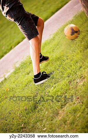 Stock Photo - Boy playing football. Fotosearch