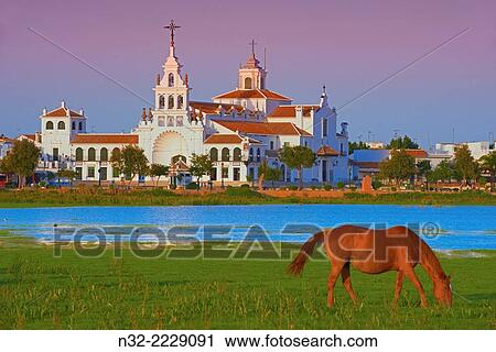 El Rocio village and Hermitage at Sunset, Almonte, El Rocio, Marismas de Doñana, Doñana National Park, Huelva province, Andalusia Spain. View Large Photo Image Stock Image - El Rocio village and Hermitage at Sunset, Almonte, El Rocio, Marismas de Doñana, Doñana National Park, Huelva province, Andalusia Spain.. Fotosearch