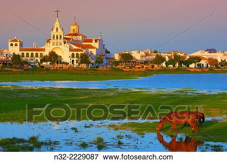 El Rocio village and Hermitage at Sunset, Almonte, El Rocio, Marismas de Doñana, Doñana National Park, Huelva province, Andalusia Spain. View Large Photo Image Stock Photo - El Rocio village and Hermitage at Sunset, Almonte, El Rocio, Marismas de Doñana, Doñana National Park, Huelva province, Andalusia Spain.. Fotosearch