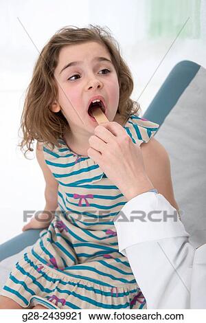 Hand of doctor pediatrician examining mouth and throat of little girl with a spatula View Large Photo Image Stock Image - Hand of doctor pediatrician examining mouth and throat of little girl with a spatula. Fotosearch