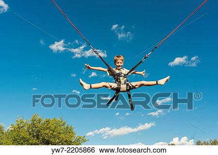 Happy boy jumping on a trampoline. View Large Photo Image Stock Photograph - Happy boy jumping on a trampoline.. Fotosearch