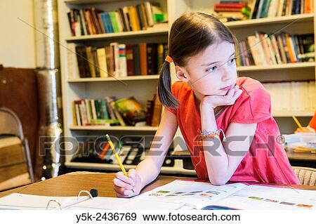 Harrison, New York, USA. Female primary school student working on a class room assignment, while sitting in front of the school´s library. View Large Photo Image Stock Photo - Harrison, New York, USA. Female primary school student working on a class room assignment, while sitting in front of the school´s library.. Fotosearch