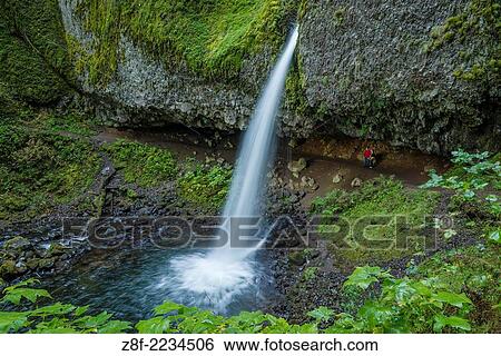 Stock Photograph - Hikers on trail behind Ponytail Falls (aka Upper Horsetail Falls), Columbia River Gorge National Scenic Area, Oregon.. Fotosearch