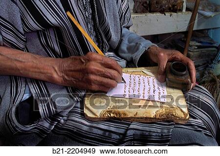 Stock Photo - Holy man preparing an amulet, Marrakech, Morocco. Fotosearch