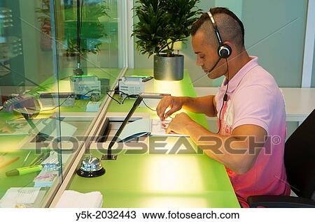 Stock Image - Klosterstrasse, East-Berlin, Berlin, Germany. South-American immigrant, living in Denmark, at the consular department of the Dutch embassy, working on his exam to retain a permit of residence for the Netherlands.. Fotosearch