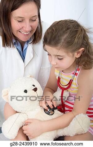 Little Girl auscultating her teddy bear with woman doctor in surgery View Large Photo Image Stock Image - Little Girl auscultating her teddy bear with woman doctor in surgery. Fotosearch