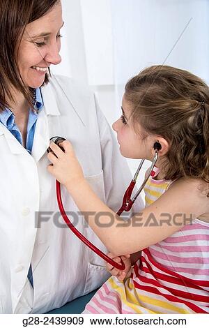 Little girl in doctor´s surgery, auscultating the woman doctor with her stethoscope View Large Photo Image Stock Photo - Little girl in doctor´s surgery, auscultating the woman doctor with her stethoscope. Fotosearch