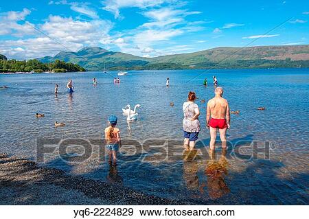 Luss, Loch Lomond and the beach with people swimming and sunbathing on a lovely summer day. View Large Photo Image Stock Photo - Luss, Loch Lomond and the beach with people swimming and sunbathing on a lovely summer day.. Fotosearch