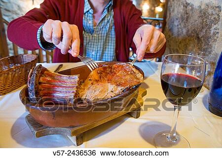 Man´s hands serving roast lamb in a restaurant. Madrid, Spain. View Large Photo Image Stock Photograph - Man´s hands serving roast lamb in a restaurant. Madrid, Spain.. Fotosearch