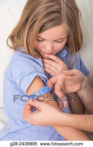 Mother putting a clean dressing on the arm of her daughter View Large Photo Image Stock Photography - Mother putting a clean dressing on the arm of her daughter. Fotosearch