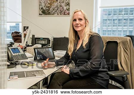 Stock Photograph - New York, USA. Consular employee at her office desk in the Dutch Consulate General, Manhattan.. Fotosearch
