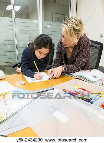 Stock Image - New York, USA. Female teacher at ´t Klokhuis, a school for Dutch language and culture, teaching a young student Dutch idiom.. Fotosearch