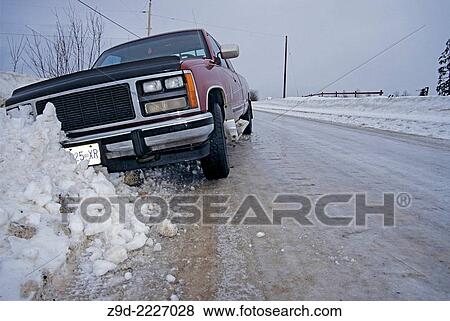 Stock Photo - Pickup truck in ditch after sliding off icy road, Smithers, British Columbia.. Fotosearch