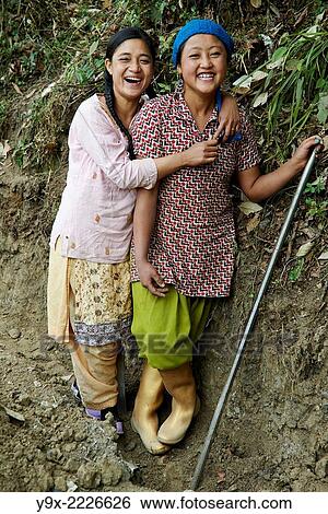 Portrait of two young Tibetan female Labor workers embracing and laughing with each other. View Large Photo Image Stock Photograph - Portrait of two young Tibetan female Labor workers embracing and laughing with each other.. Fotosearch