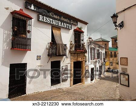 Stock Image - Restaurant Santa Pola, on background Palacio del Rey Moro or Casa del Rey Moro Palace or House of the Moorish King, Cuesta de Santo Domingo street, Ronda, White Towns, Malaga province, Andalusia, Spain, Europe.. Fotosearch