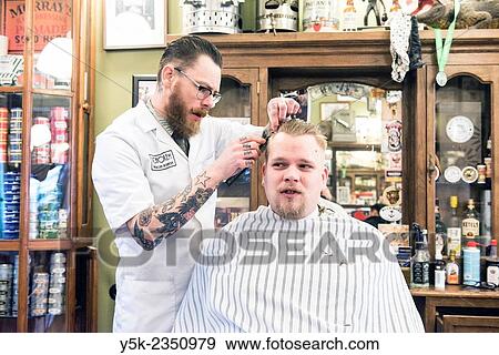 Rotterdam, Netherlands. Barber store Schorem. Barber helping his customer in his barber shop by cutting and modeling his hair. View Large Photo Image Stock Photo - Rotterdam, Netherlands. Barber store Schorem. Barber helping his customer in his barber shop by cutting and modeling his hair.. Fotosearch