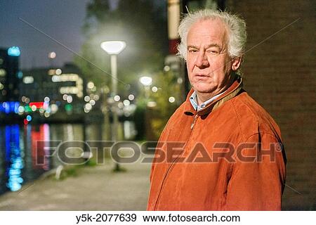 Rotterdam, Netherlands. Elder caucasian male, walking along the old harbor during nightfall. View Large Photo Image Stock Photo - Rotterdam, Netherlands. Elder caucasian male, walking along the old harbor during nightfall.. Fotosearch