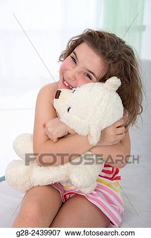 Smiling and laughing little girl cuddling her teddy bear View Large Photo Image Stock Photo - Smiling and laughing little girl cuddling her teddy bear. Fotosearch