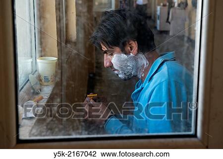 Sofia, Bulgaria. Male, Syrian refugee in refugee camp Voenna Rampa shaving in front of an open window. View Large Photo Image Stock Image - Sofia, Bulgaria. Male, Syrian refugee in refugee camp Voenna Rampa shaving in front of an open window.. Fotosearch