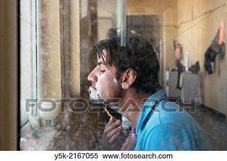 Sofia, Bulgaria. Male, Syrian refugee in refugee camp Voenna Rampa shaving in front of an open window. View Large Photo Image Stock Photography - Sofia, Bulgaria. Male, Syrian refugee in refugee camp Voenna Rampa shaving in front of an open window.. Fotosearch