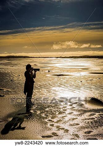 Stock Image - Taking pictures on the beach at Stokksnes, Eastern Iceland.. Fotosearch